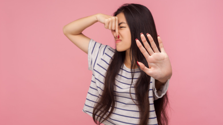 woman holding nose