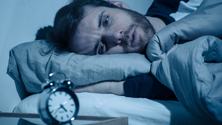 Man in bed struggling with insomnia