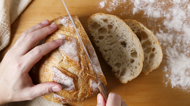 Man slicing sourdough bred