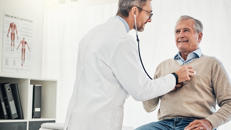 Doctor checking man's heart