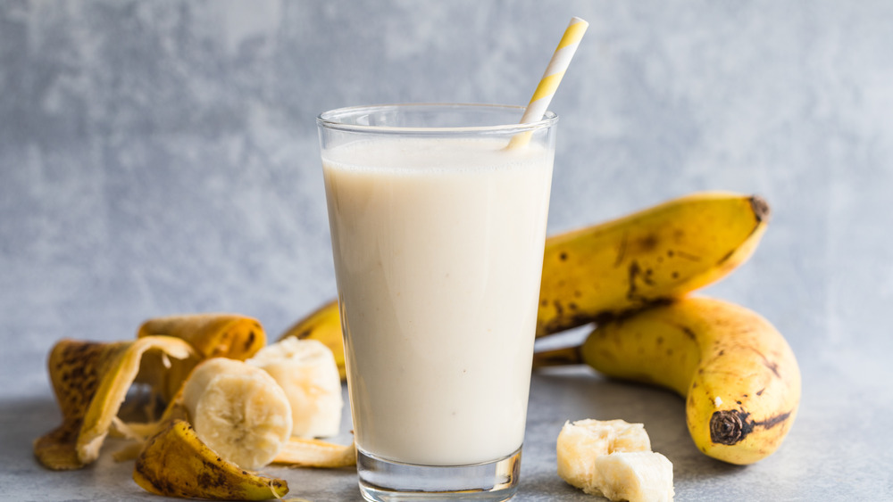 Bananas, banana smoothie in glass with straw