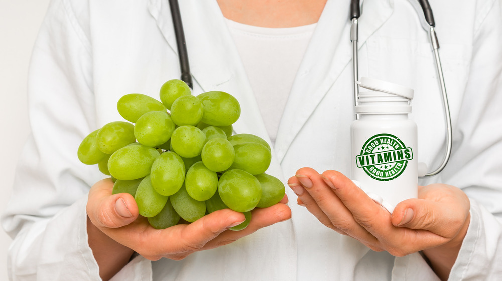 doctor holding grapes and vitamins