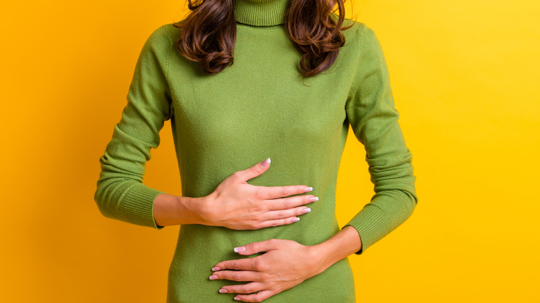 woman touching stomach in pain