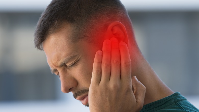 a man grabbing his ear in pain indicating inflammation