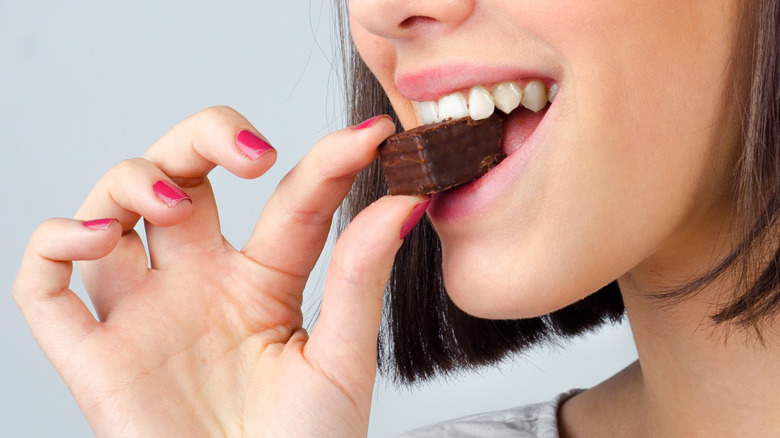 Close up of a woman biting into chocolate