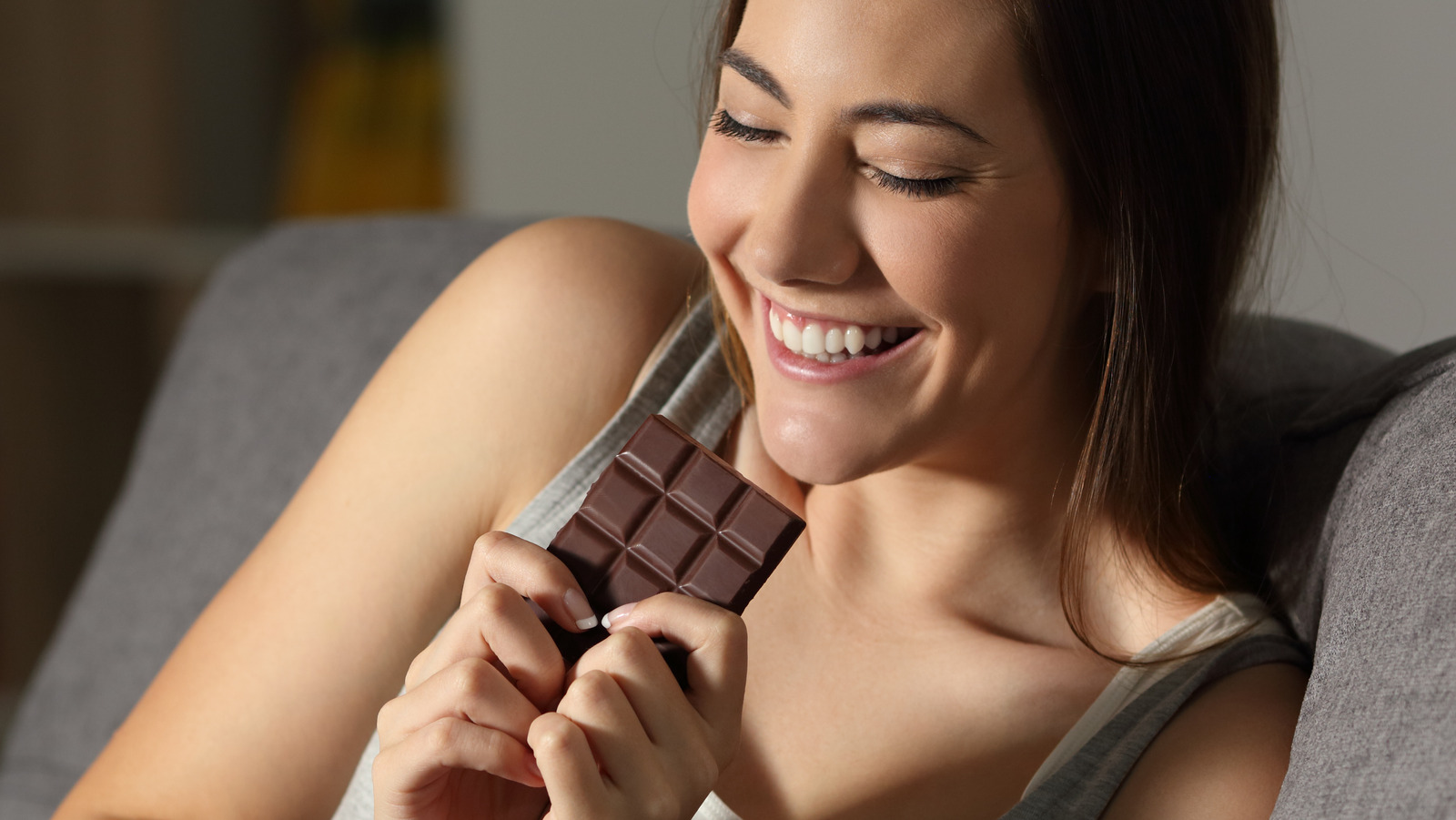 Beautiful girl eating chocolate on white background Stock Photo - Alamy