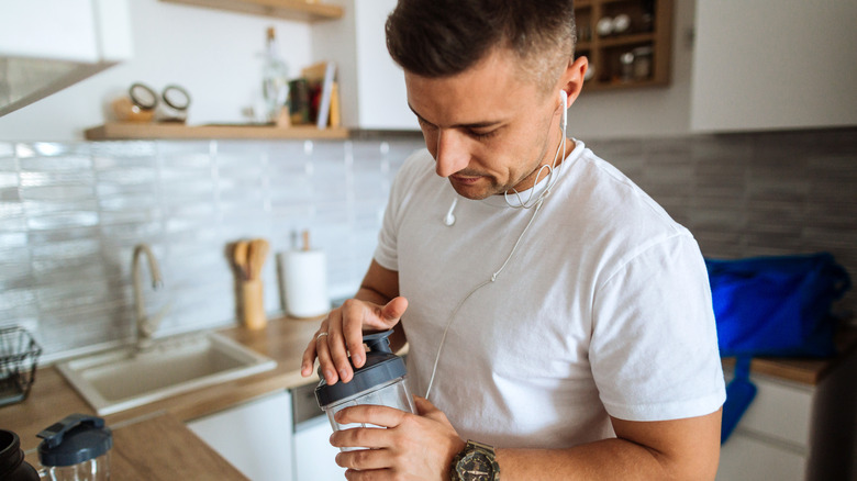 man preparing a whey protein shake