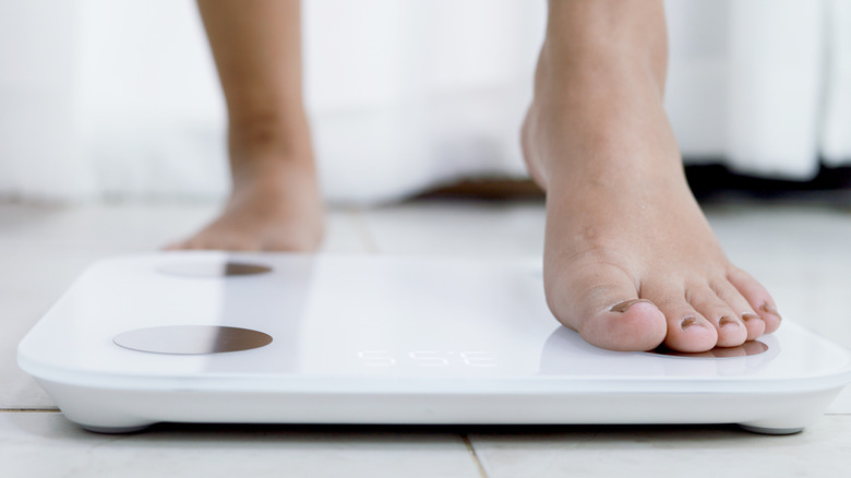 person stepping onto a scale
