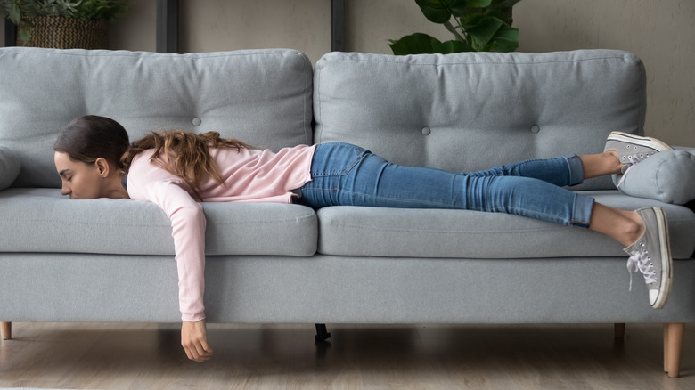 young woman exhausted on couch