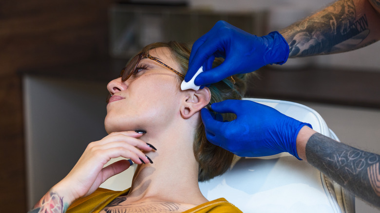 woman gets a cartilage ear piercing