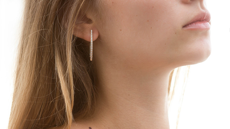 white woman with gold and gemstone hoop earrings