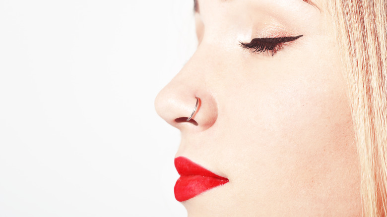 close up of hoop nose piercing in white female