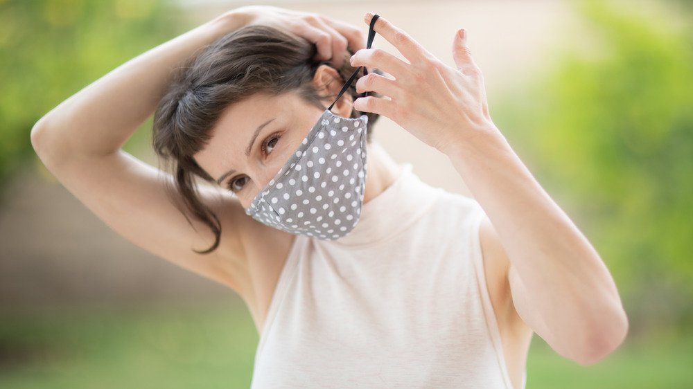 Woman putting her mask back on 
