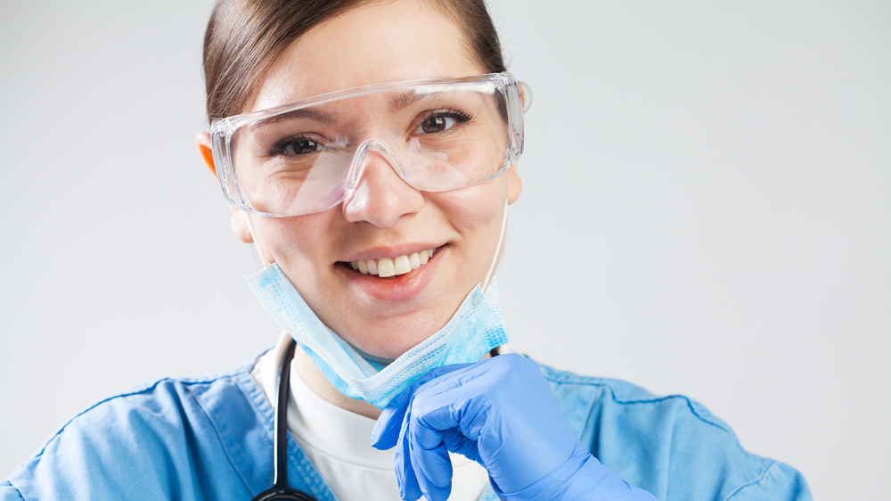 Female scientist pulling mask down to show she's smiling