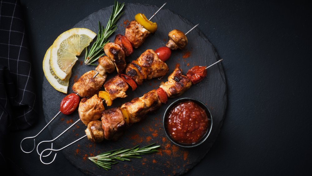 Meat kebabs on a plate with dipping sauce