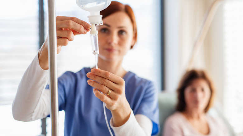 nurse adjusting IV