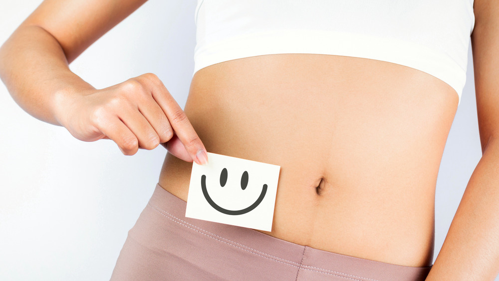 woman with smiley face next to gut