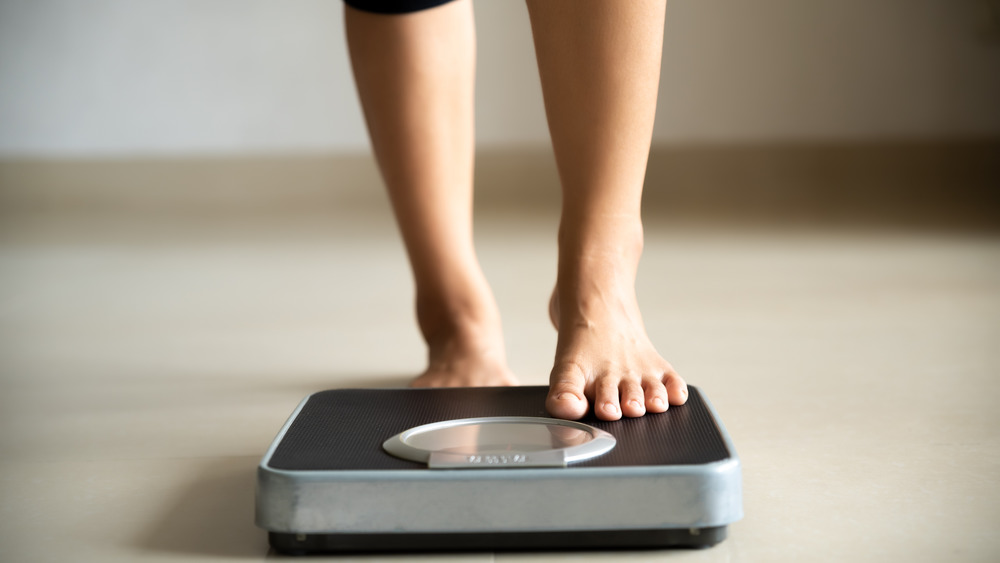 woman stepping on scale