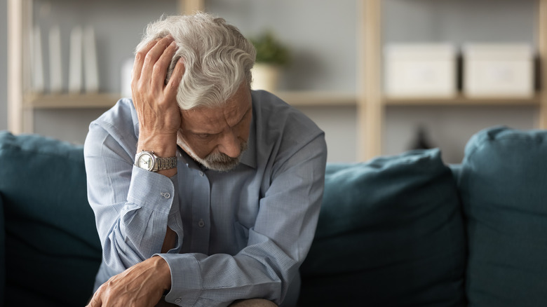 man thinking and holding hand to head