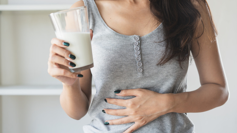 Woman with glass of milk and stomach distress