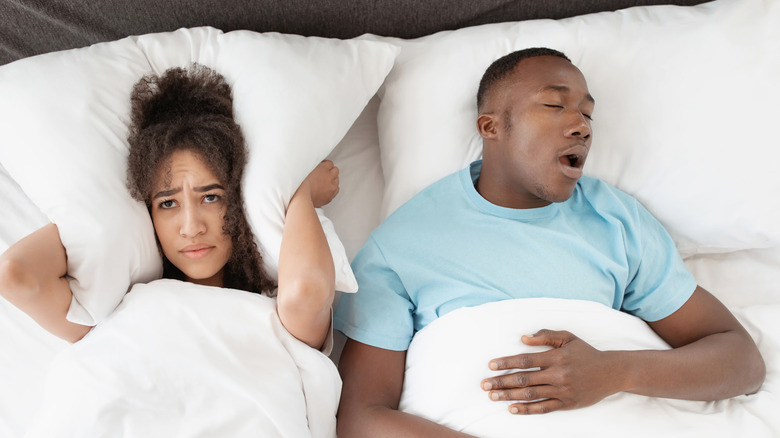 Snoring man and frustrated woman