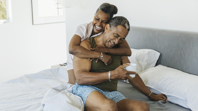 Smiling couple laughing in bed