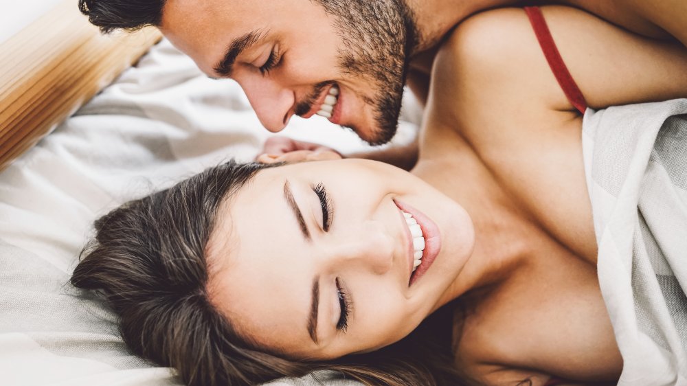 A smiling couple in bed together