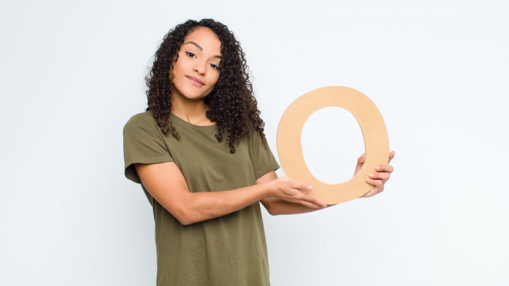 A woman holding the letter "O"