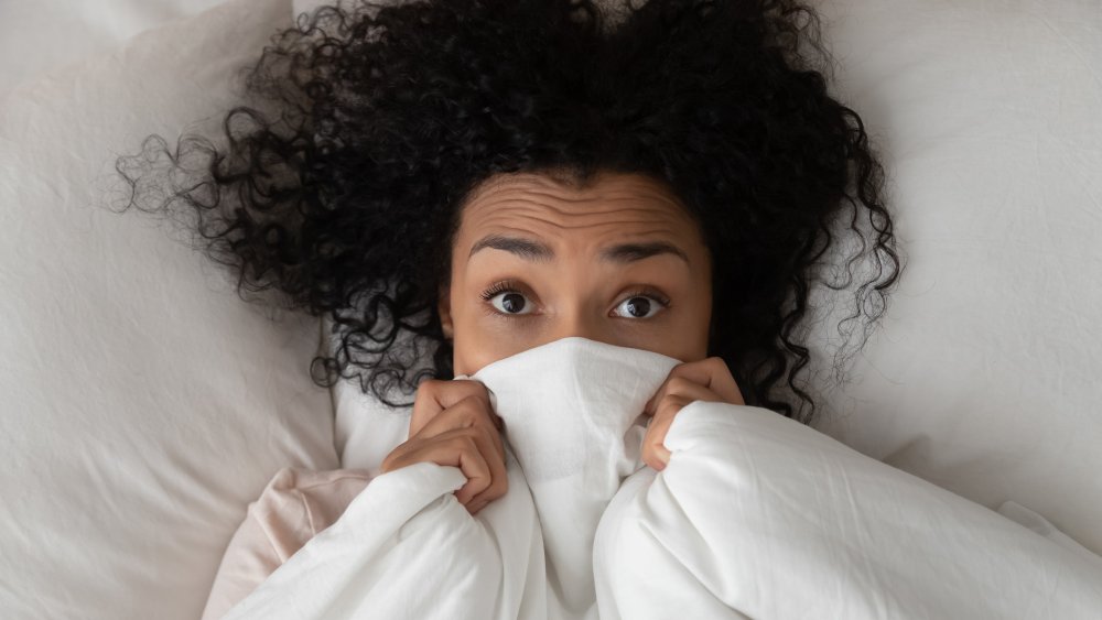 woman with covers partially over face