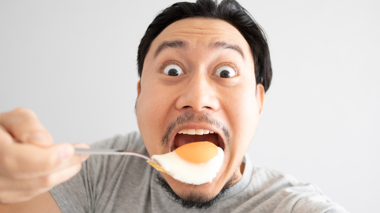 A smiling egg-eating man