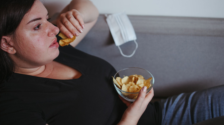 a depressed potato-chip-eating woman