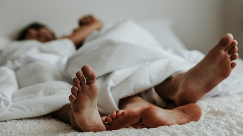 Feet of romantic couple in bed