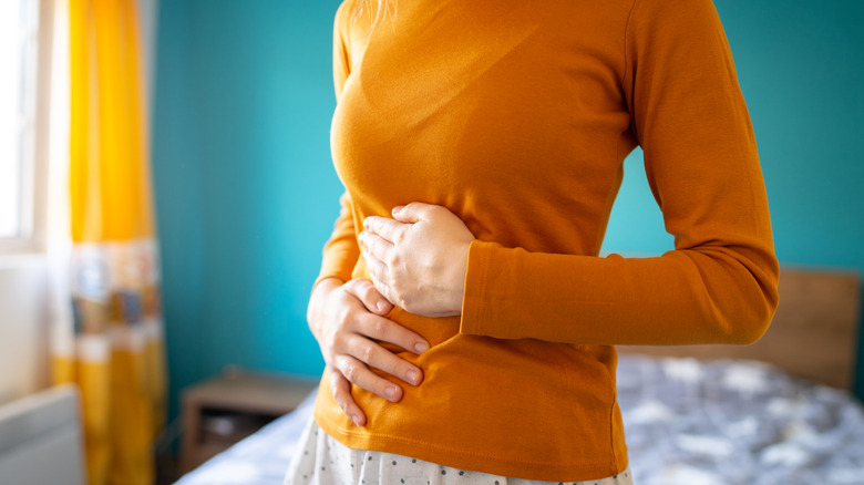 Woman holding her stomach with bladder pain