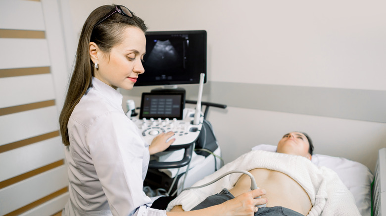 Female doctor performing ultrasound on woman's bladder