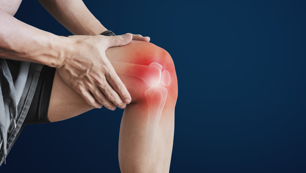 man clutching knee with joint pain