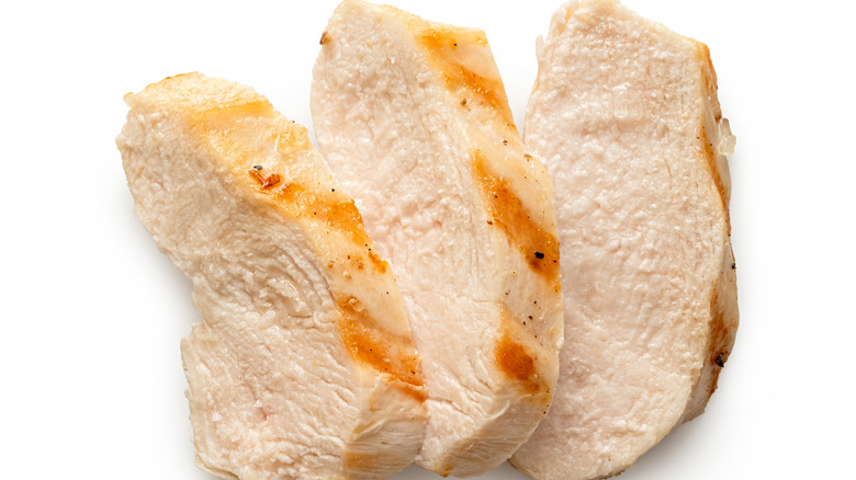 Slices of grilled chicken on white background