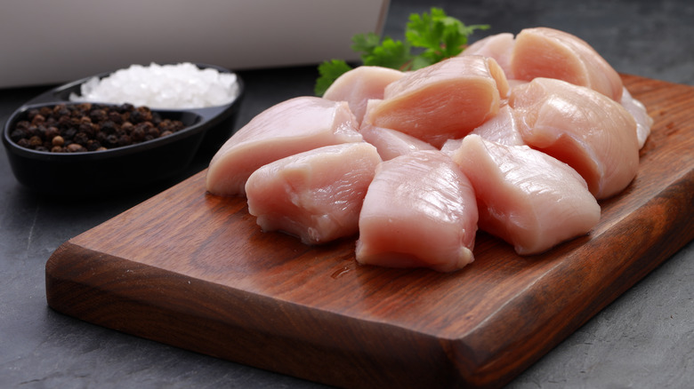 Raw chicken pieces on cutting board