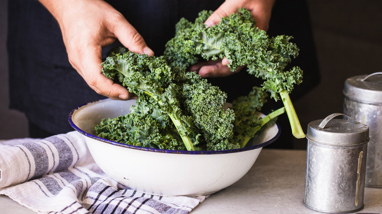 Man washing kale in bowl