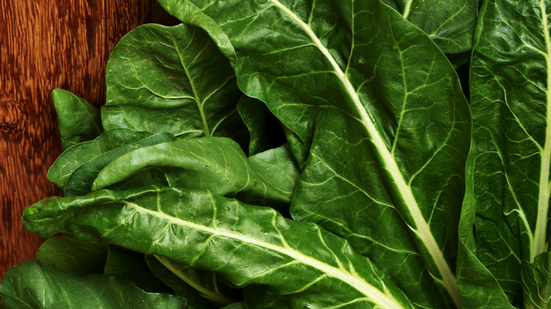 Swiss chard leaves against wooden surface