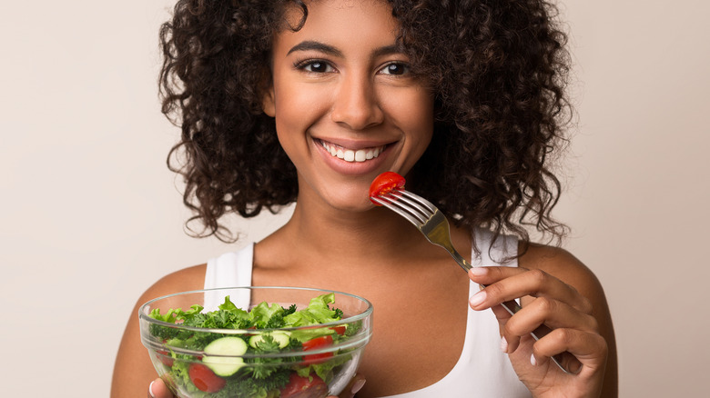 woman eating salad in bowl