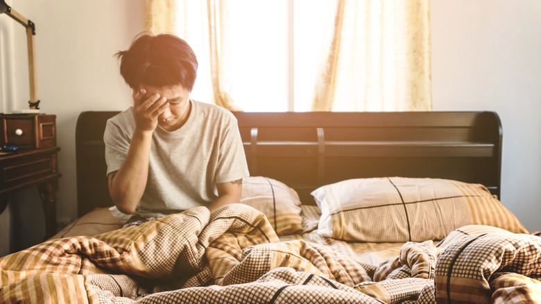 Young man waking up in bed