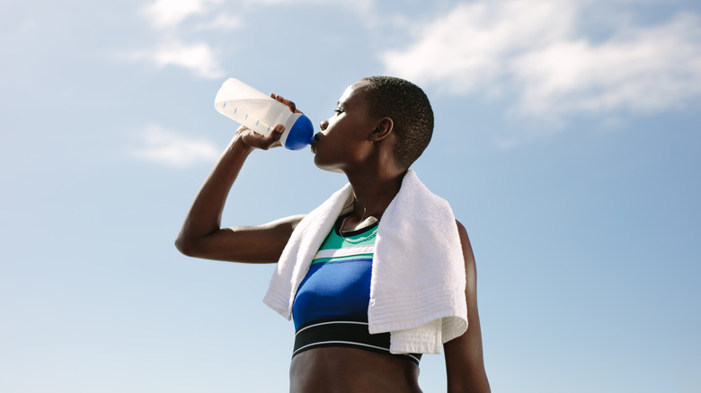 female runner drinking water