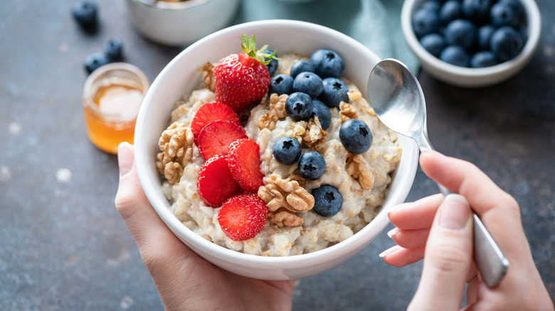 A bowl of oatmeal with berries and walnuts