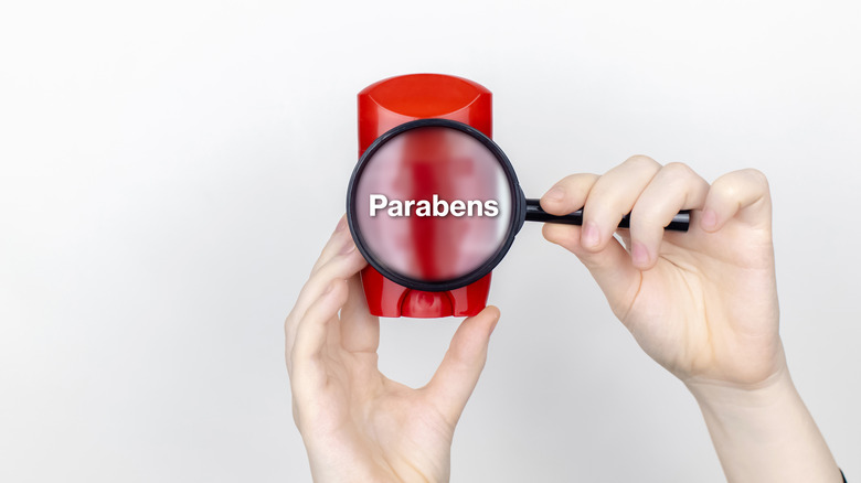 a magnifying glass hovering over deodorant with the words parabens    