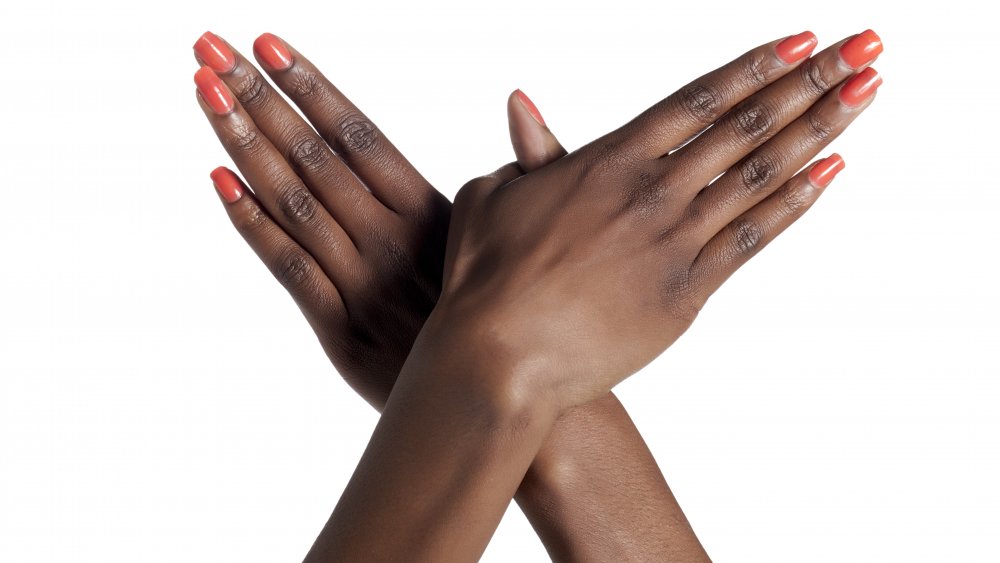 Black woman's hands with pink painted fingernails