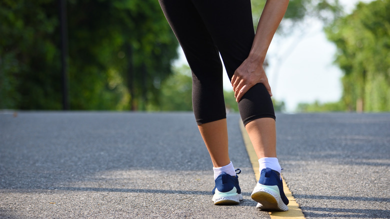 woman holding leg in pain