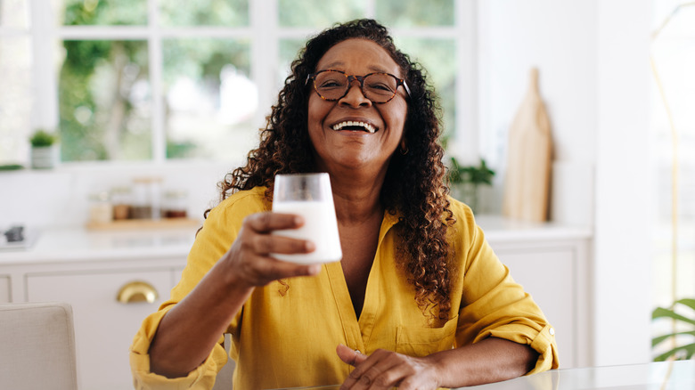 older woman toasting a glass of milk