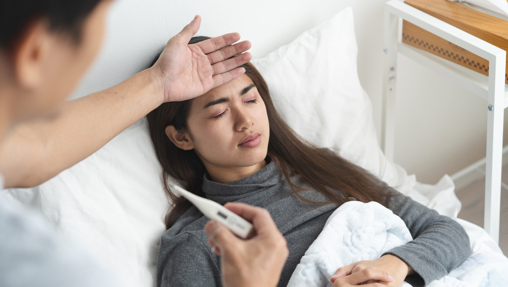 Man taking woman's temperature