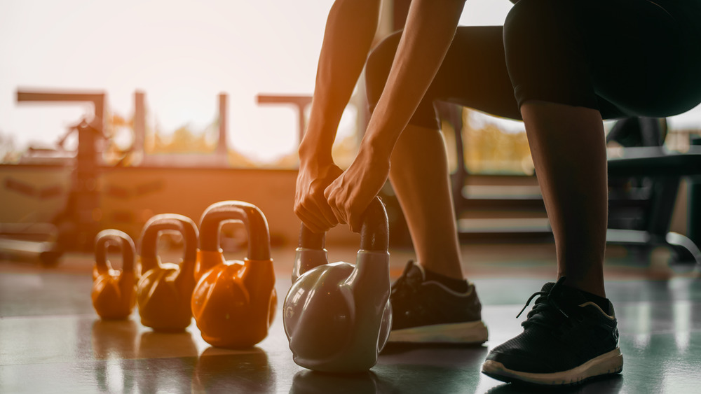 woman lifting kettleball