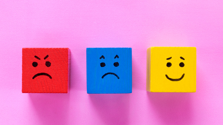 Colored cubes with faces showing anger, sadness, and happiness emotions